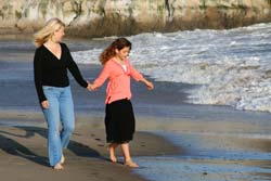 Mother and daughter walking on the beach